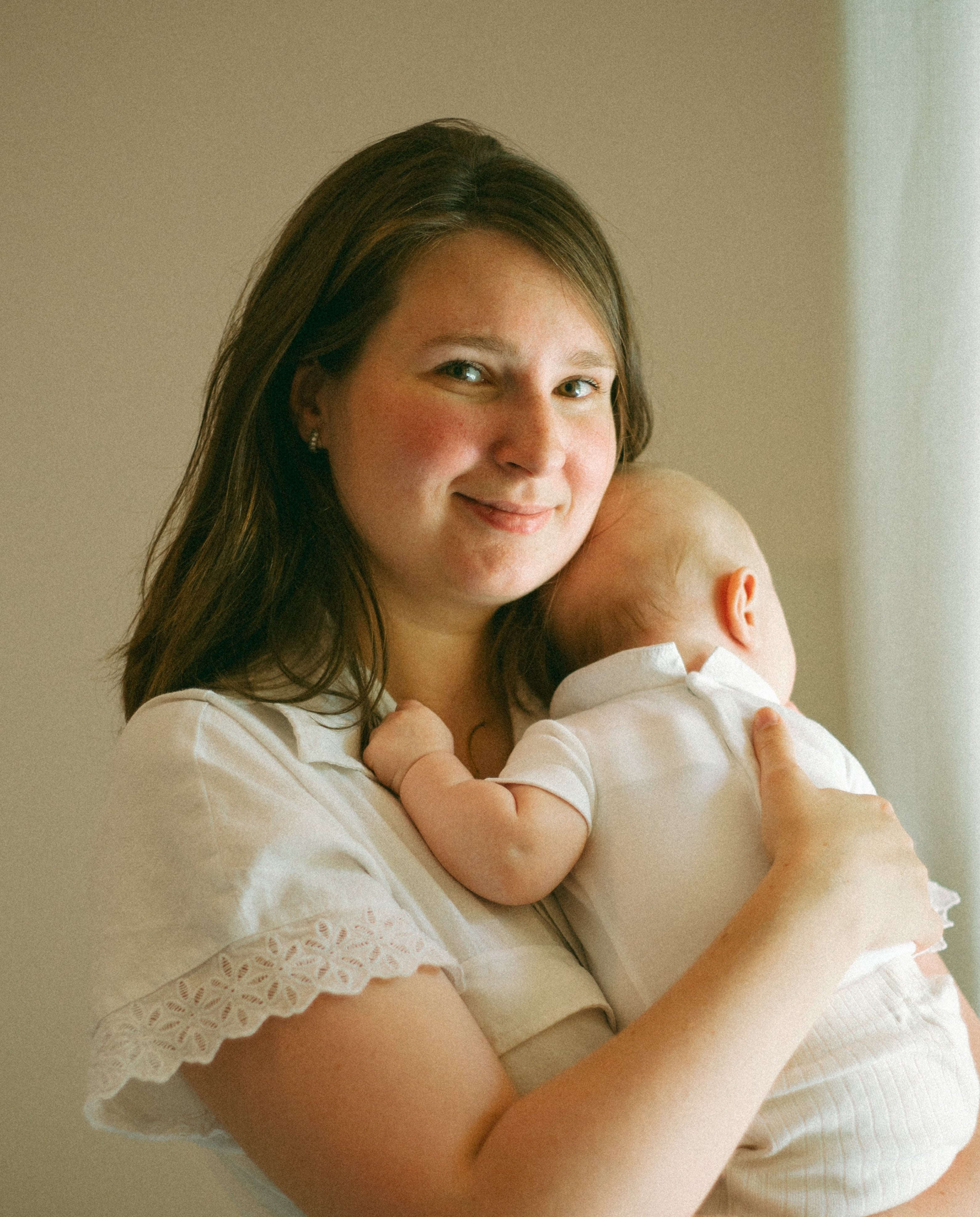 Woman holding a baby in a softly lit room